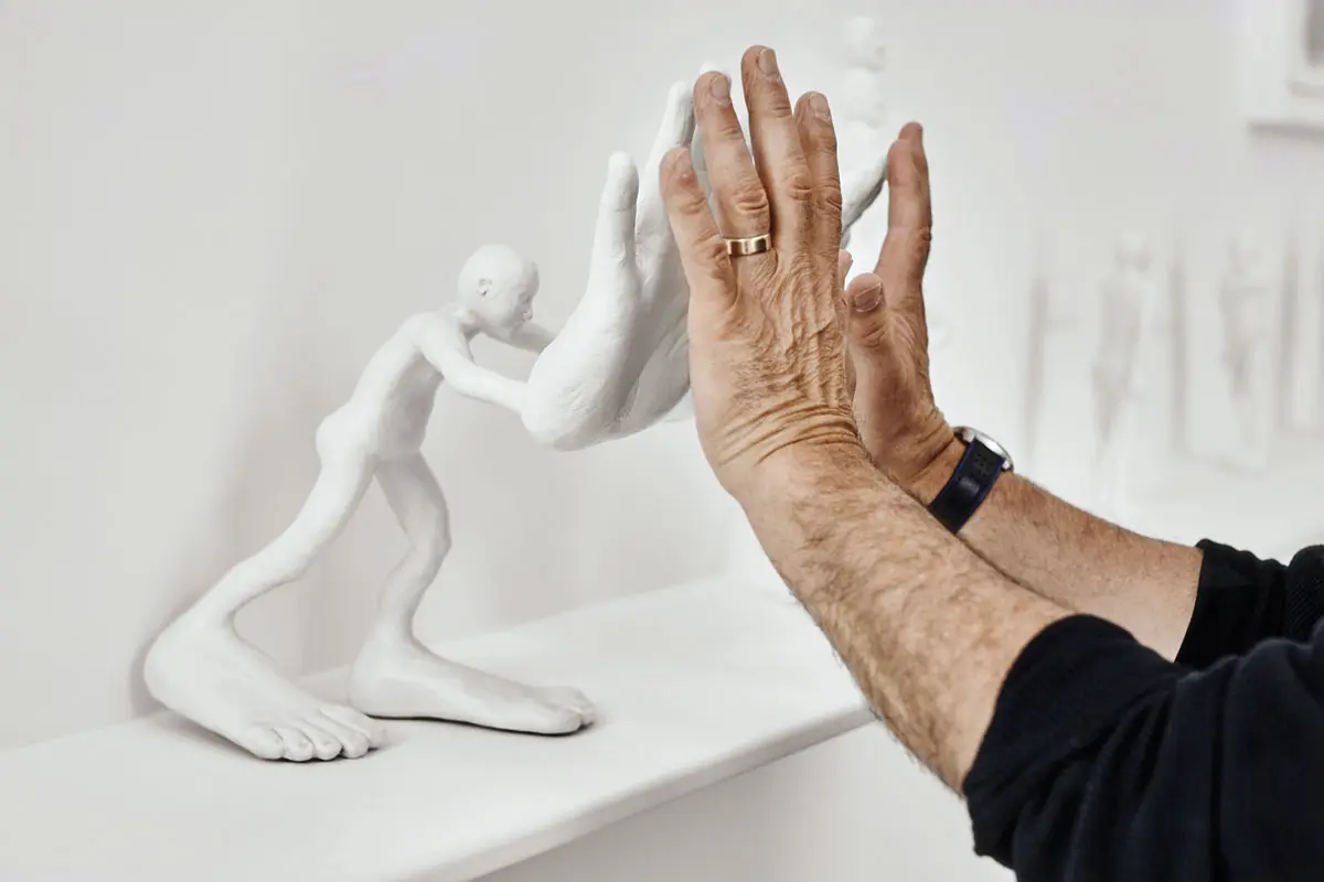 The artist interacts with his painted cast aluminum sculpture big hands, 2011.