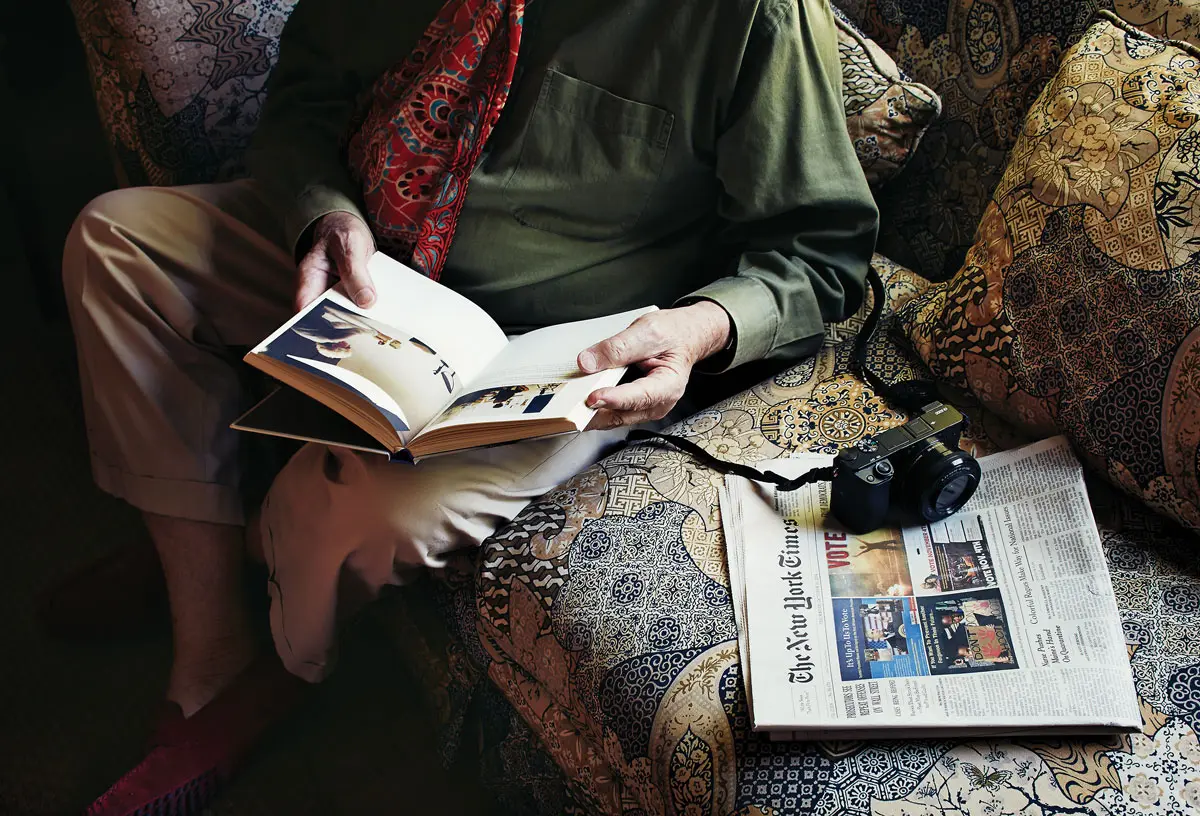 Fred, seated in the living room with a digital Sony 600 camera, which he uses for casual photography.