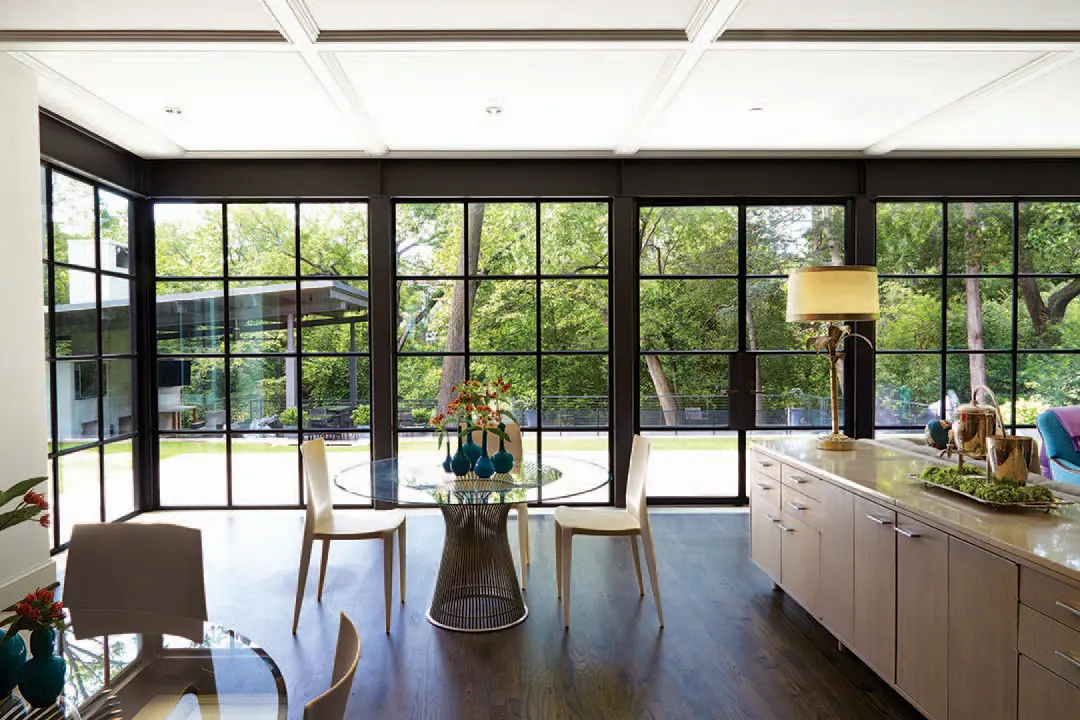 An informal dining area is separated from the family room by a 10-foot buffet that belonged to the husband’s parents in New Orleans. Tables Warren Platner for Knoll. Kartell kid-proof chairs.
