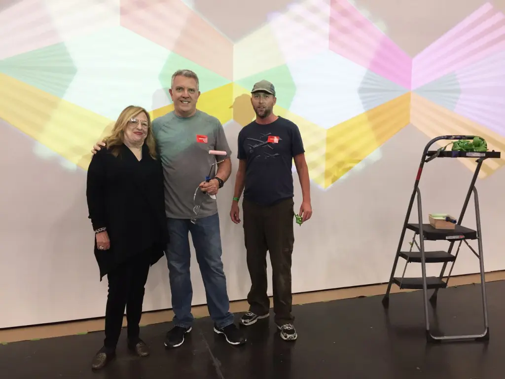 Jay Shinn (middle) and dealer Barbara Davis bask in his light installation.