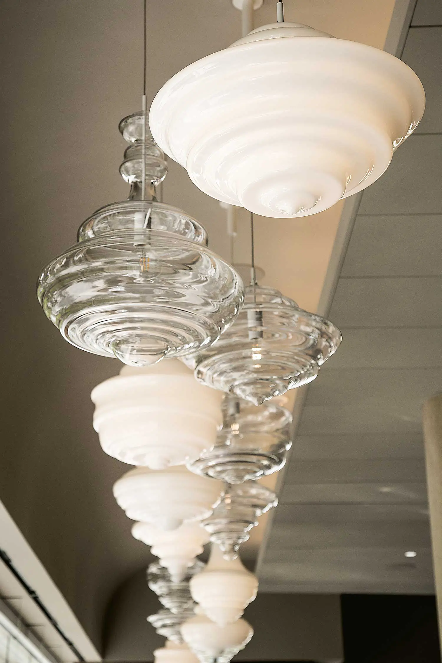 Glass chandeliers suspended at different heights in the dining room (Photo by Imani Chet Lytle)
