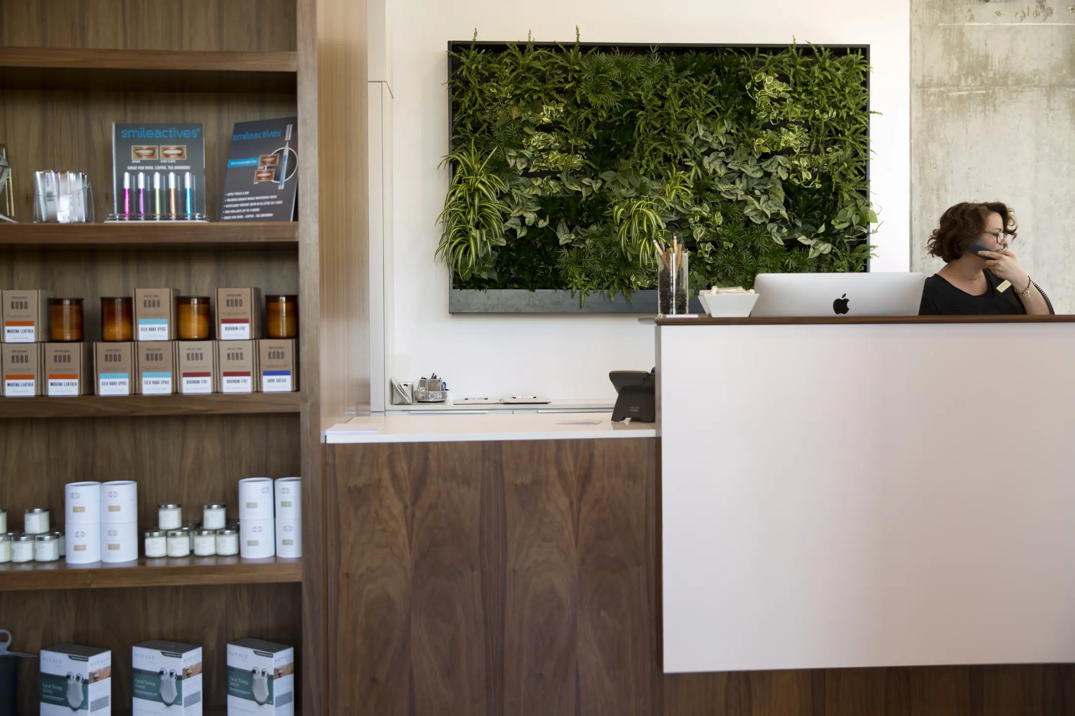 A budding plant wall greets guests at Milk + Honey's entrance.