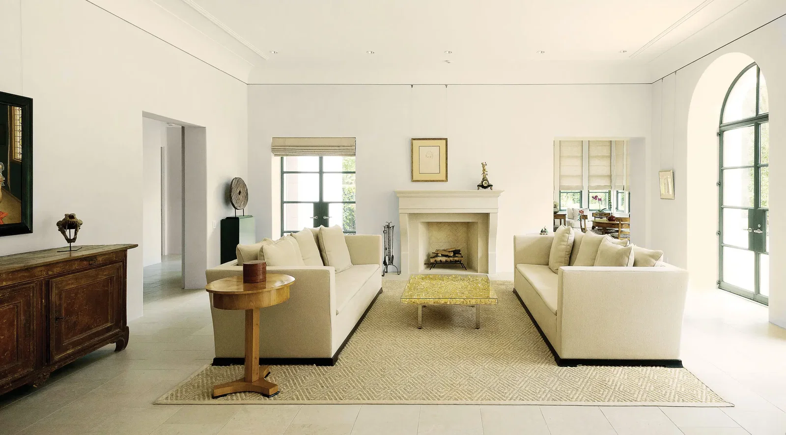 One end of the living room features two Armani Casa sofas from Kuhl-Linscomb, covered in beige linen. Between them, Yves Klein’s Table d’Or. In the foreground, one of a pair of Biedermeier-style tables from Eastern Europe; atop the table, an antique Burmese lacquer box.