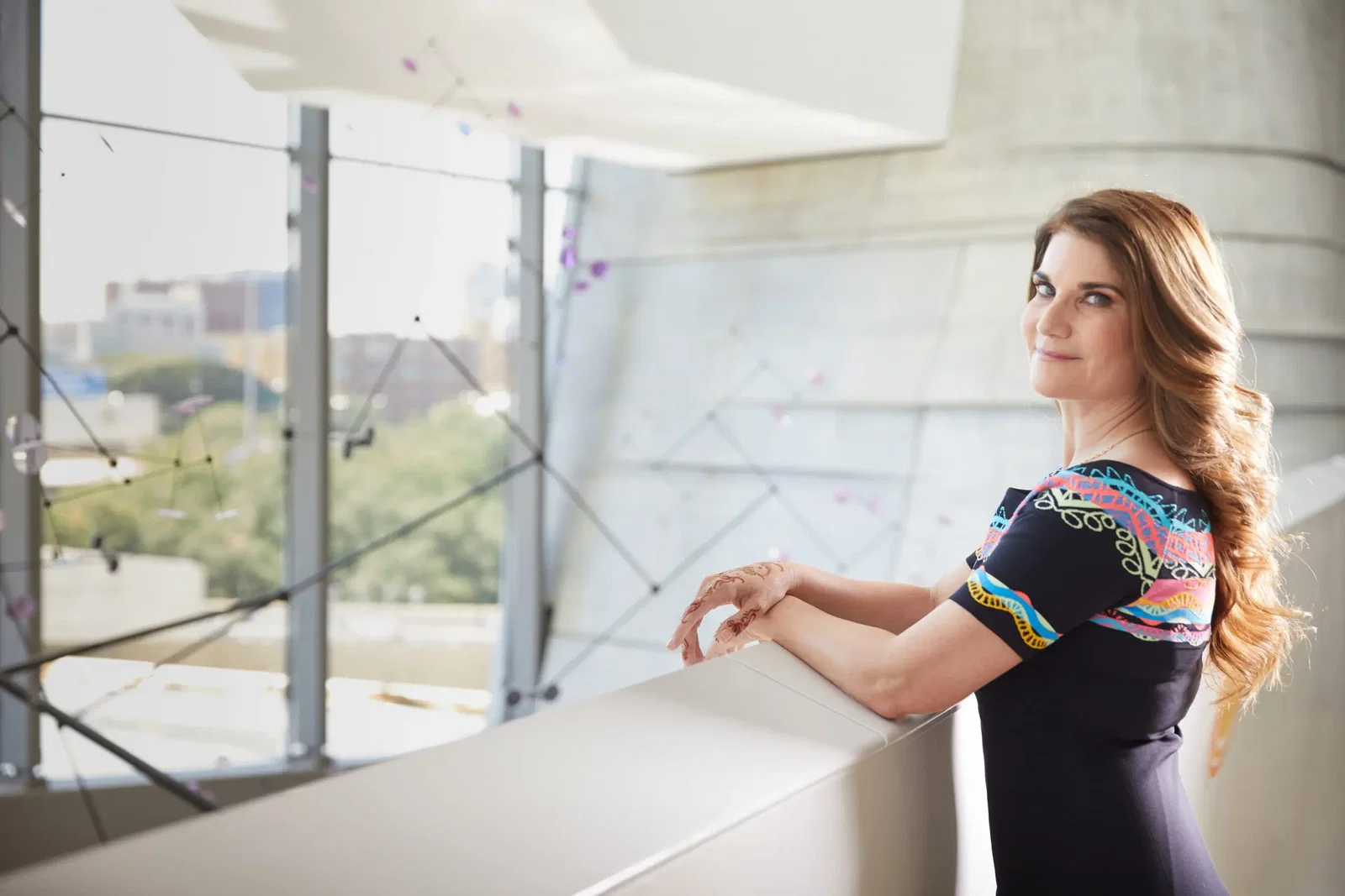 Dr. Abraham-Silver inside the Perot Museum. She stands next to "Superorganism,” 2012, a kinetic sculpture by England-based artist Daniel Chadwick. Solar cells capture sunlight to power small motors embedded in the sculpture. When enough solar energy is collected, the motors rotate.
