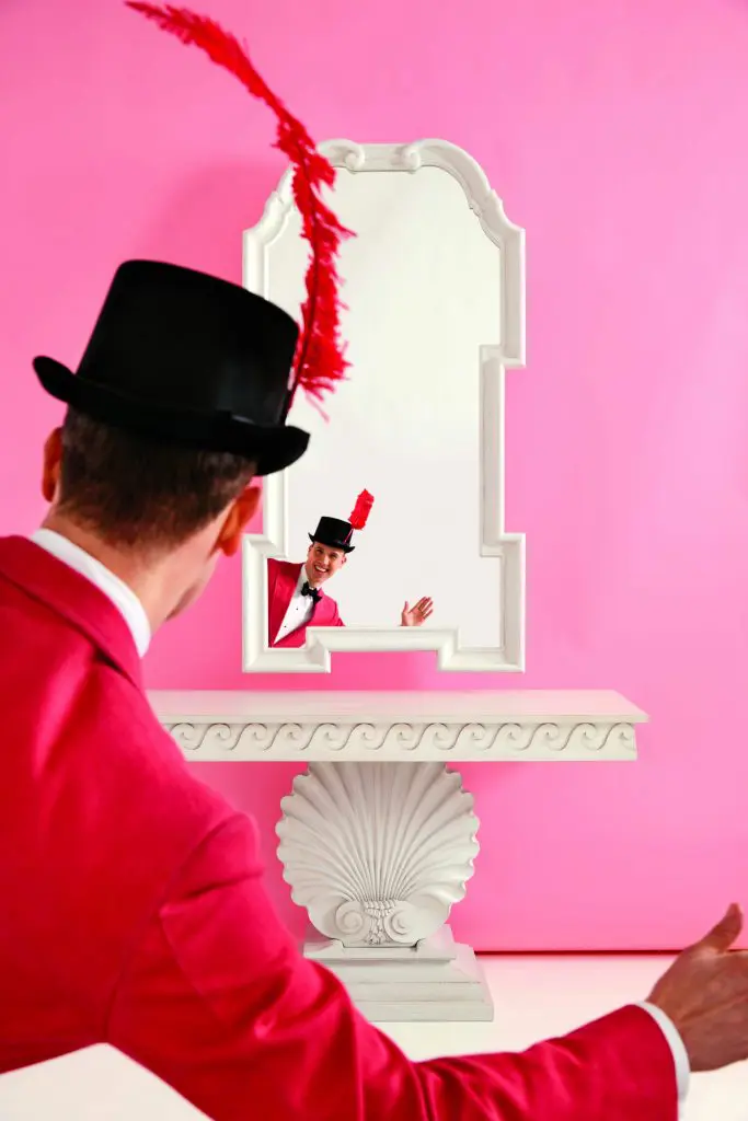 Miles Redd waves to his reflection in the Queen Anne Hollywood mirror above the Shell console