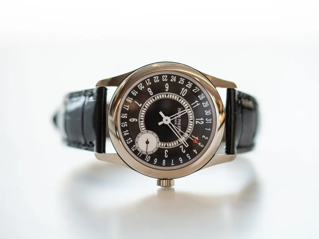 Iconic Patek Philippe 18K gold Calatrava watch with date indicator and offset seconds dial.