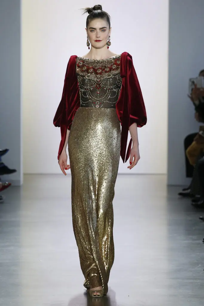 An ornate Badgley Mischka gown with a gold sequined long skirt, burgundy velvet sleeves, and ornately beaded bodice and back that looks tailor made for "The Crown."(Photo courtesy of Badgley Mischka)