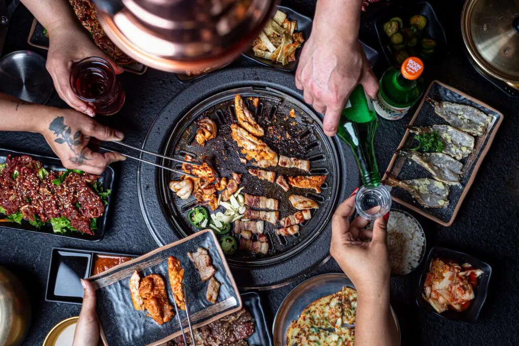 An array of dishes and drinks, the former grilled at your table at the new Chinatown restaurant called Hongdae 33. (Photo by Jenn Duncan)