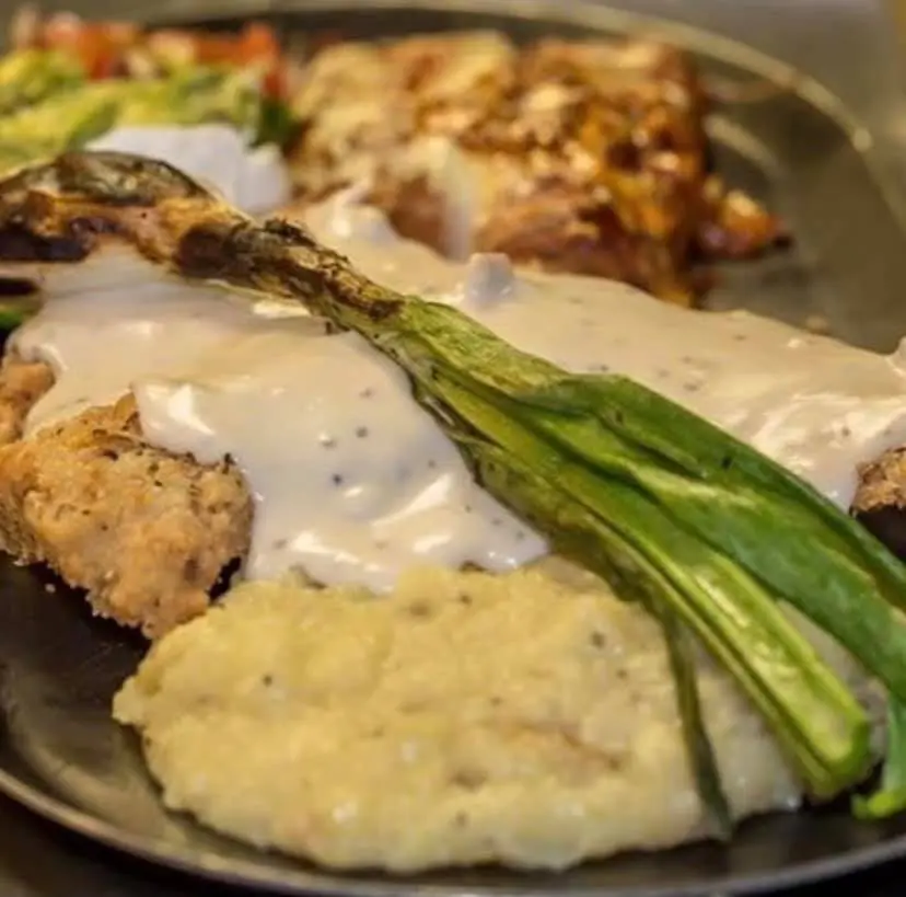 Chicken fried steak served the cowboy way with peppered cream gravy, then sided with ancho cheese enchiladas, The Vaquero Way.
