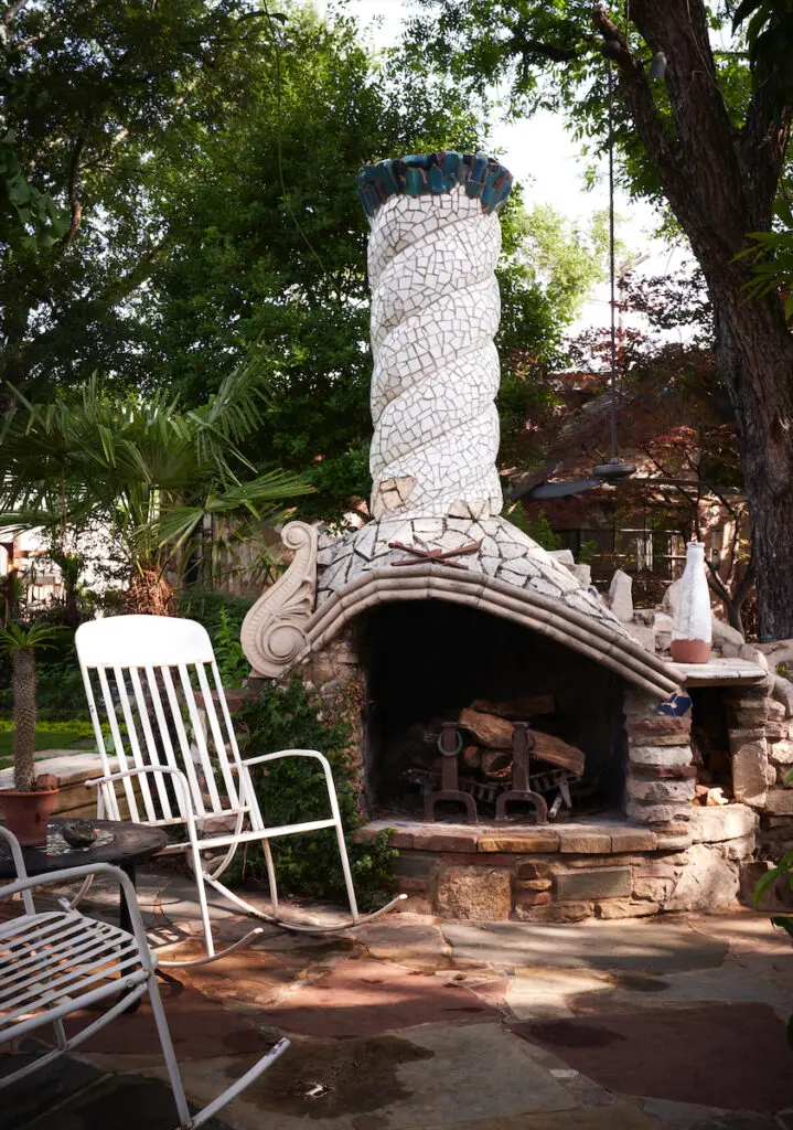 The outdoor fireplace in renowned landcsape architect Robert Bellamy's Dallas compound features a  twisted chimney inspired by Spanish architect Antoni Gaudí’s trencar-style mosaics.(Photo by Pär Bengtsson)