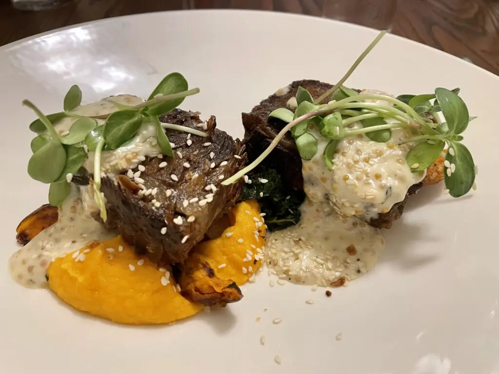 Beef short rib draped with both a sesame garlic crumble as well as a punchy pickled mustard butter sauce. (Photo by Courtney Dabney)