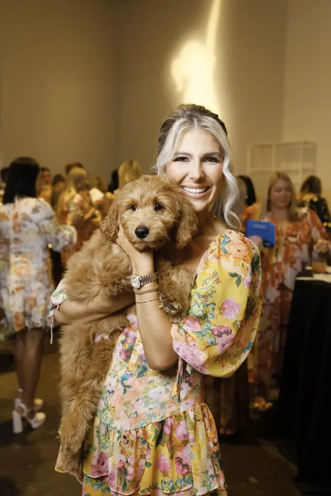 Marti Grizzle with the baby Goldendoodle presented for the live auction at the Ladies Who Brunch benefit for Sky High for Kids at The Revaire. (Photo by Quy Tran Photography)