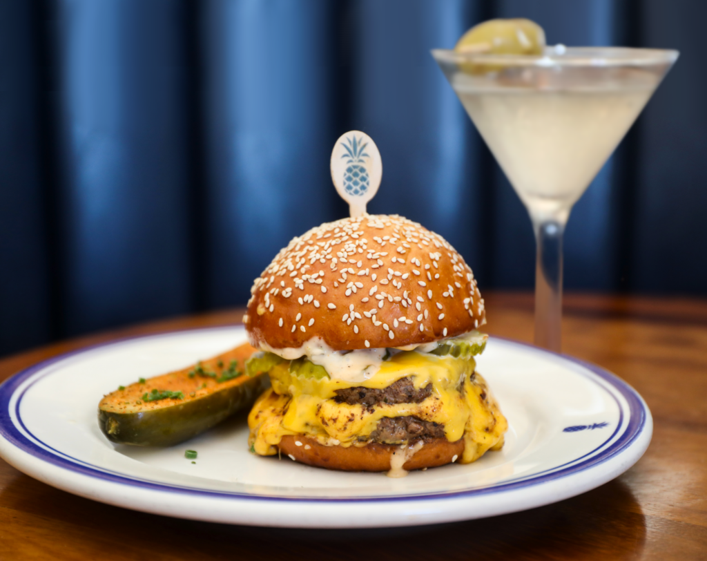 One of the signatures of the Hudson House menu is the cheeseburger built on two beef patties. By its side, one of their signature chilly martinis. (Photo by Becca Wright)