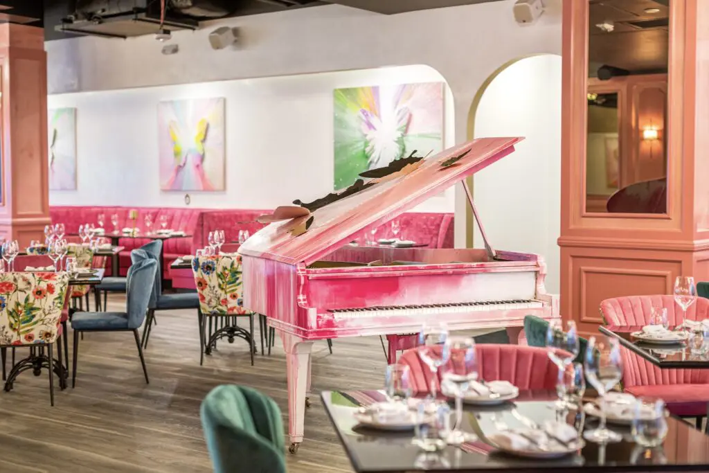 A hand-painted pink grand piano at Post Script was created by artist Roman Lefebvre who also created the butterflies festooning the exterior of the building, the former stead of Del Frisco's Grille. (Photo by Jenn Duncan)