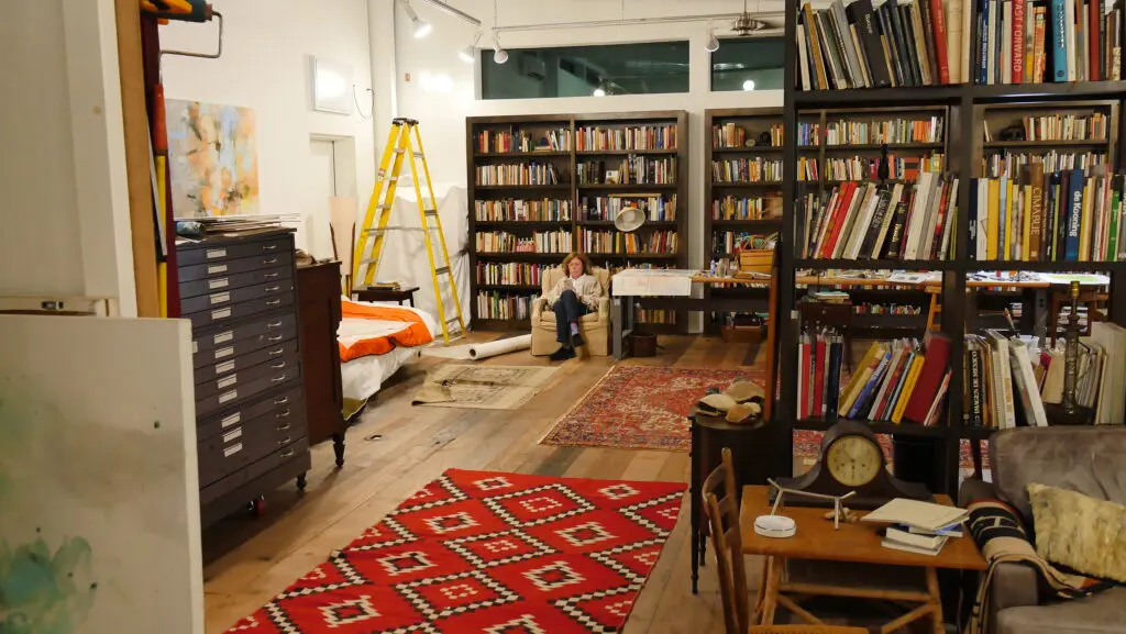 Artist Terrell James relaxes for a moment near the library within her studio. (Photo by Cameron Armstrong)