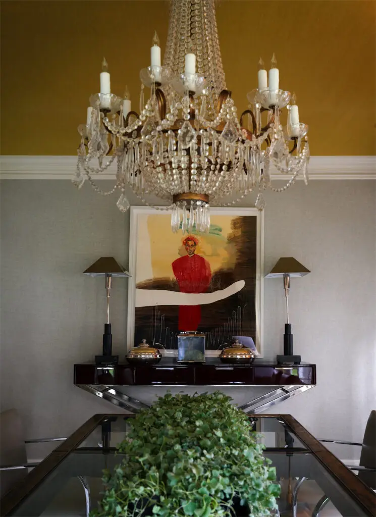 In the dining room, Julian Schnabel painting from McClain Gallery, Ralph Lauren console, and a French Regency chandelier. (Photo by Pär Bengtsson)