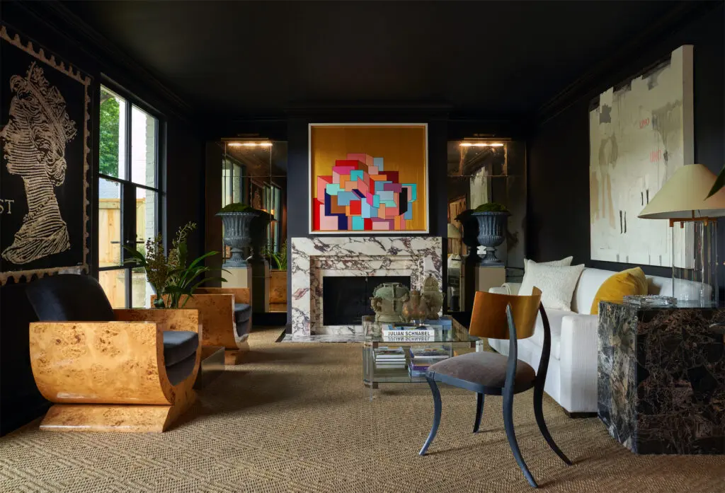 Designer Catherine Brooks Giuffre painted the living room in Sherwin Williams Caviar. The burlwood chairs were purchased from antiquarian Carl Moore’s personal collection and re-covered in Holland & Sherry mohair. Giuffre designed the mantel in Calacatta Viola marble. Antique urns from Found. Coffee table, 1970s, from Lewis & Maese Antiques & Auctions. The Wicker Works Klismos chair. Custom sofa in Mokum fabric. Marble side table is a flea-market find. Brooks lamp by J. Randall Powers for Visual Comfort. Artworks, from left, by Ann Carrington, Juan Carlos Muñoz Hernandez, and Beatriz Cotta. (Photo by Pär Bengtsson)