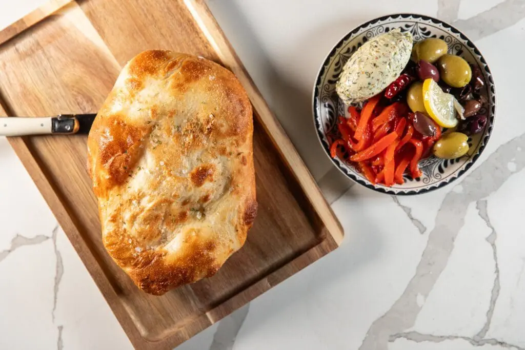 One of the signatures of all Sof Hospitality’s concepts is the crave-worthy house-baked breads. Here frena, a Moroccan fluffy cousin of pita, is paired with a pistachio studded whipped butter, an array of olives, and pickled red peppers ($9). (Photo by Becca Wright)