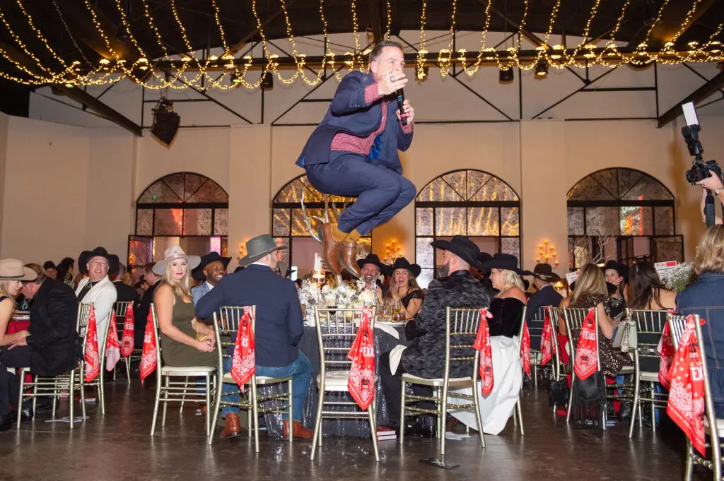 Auctioneer Johnny Bravo takes a leap at Crime Stoppers record breaking gala held at The Revaire. (Photo by Jacob Power)