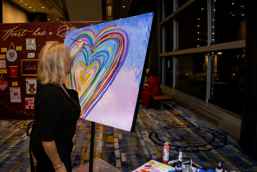 Artist Salli Babbit prepares a painting for auction at the American Heart Association Heart Ball. (Photo by Christina Griffin)