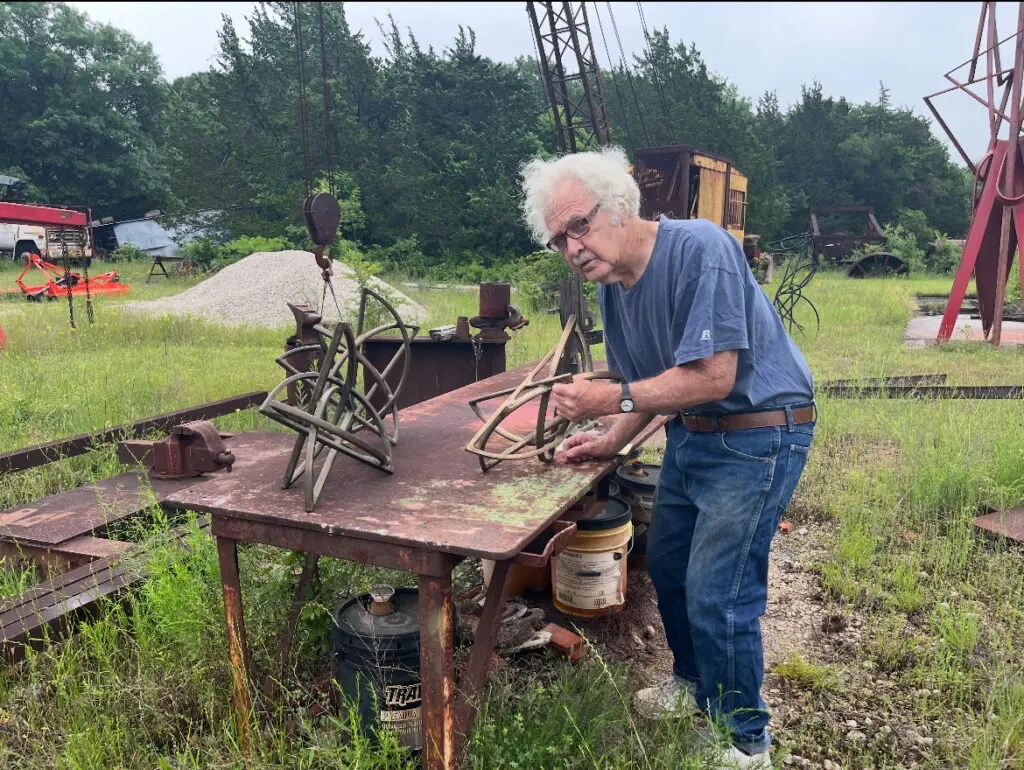 Artist Mac Whitney works outdoors at his Ovilla, Texas property, which included his studio. Whitney passed away earlier in spring 2025. (Courtesy Andrew Durham, Gallery)