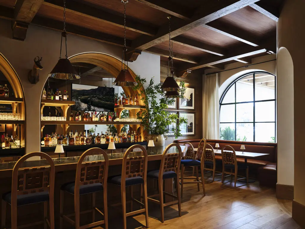 The bustling bar area is built upon honed stone, leather-wrapped chairs, and patinaed metals, where much of the art hung gallery-style is curated from Knight’s own collection of works by John Cowan and Fritz Scholders, as well as a pair of signed Picassos. Photo by Frank Frances.