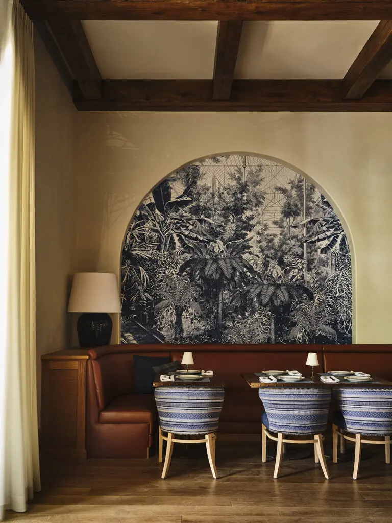 The ivory hand-troweled plaster walls are adorned on one side with several graceful arches inset with an azure-hued tropical wallcovering. Photo by Frank Frances.