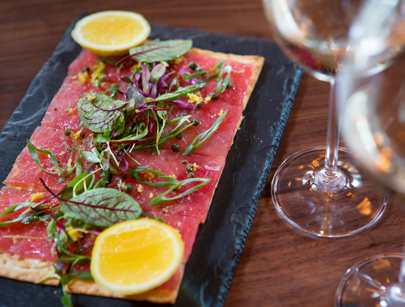 Have a glass of wine and a flatbread at TABLE on Post Oak's Forever Summer Happy Hour. 