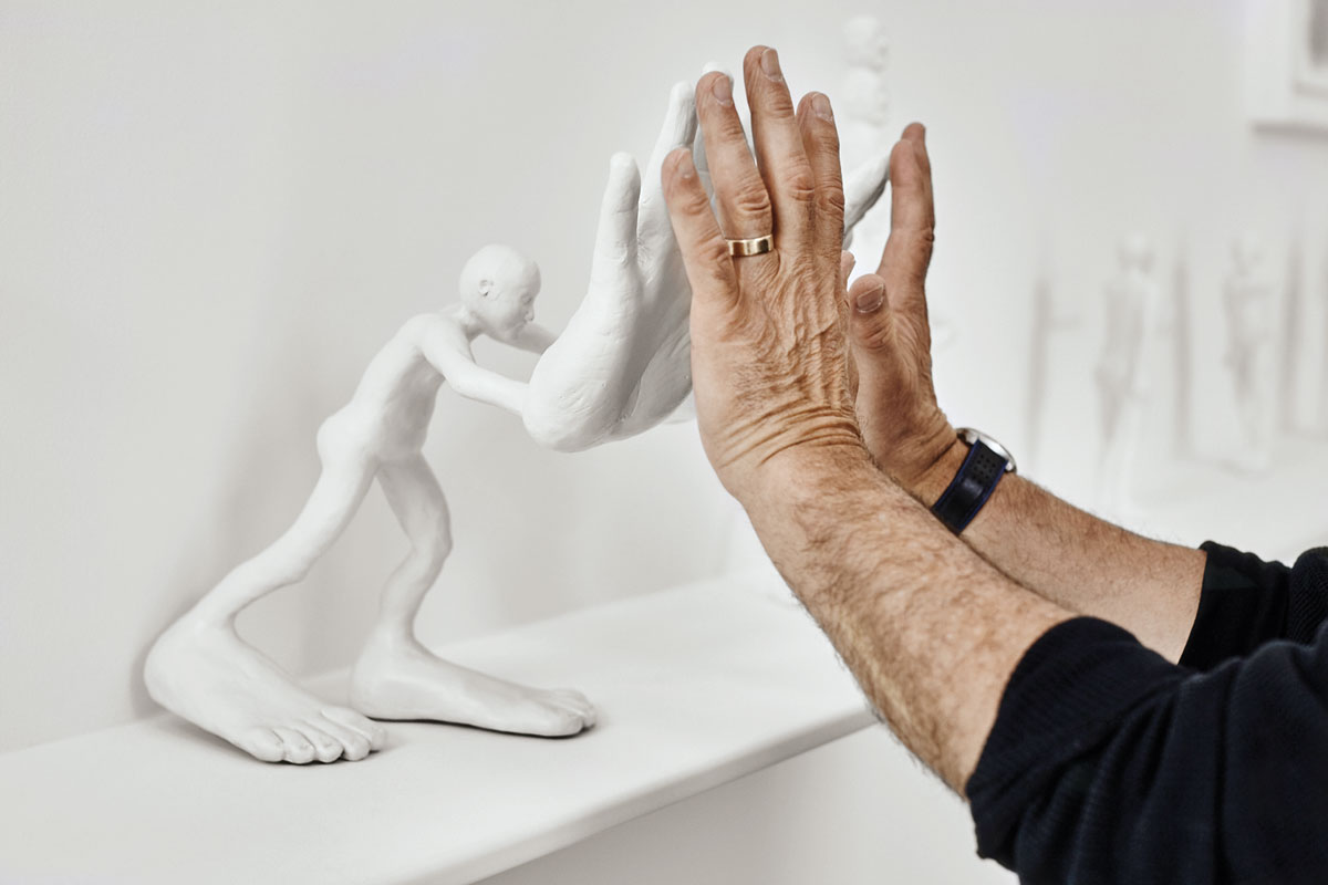 The artist interacts with his painted cast aluminum sculpture big hands, 2011.