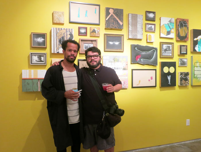 Jonathan Paul Jackson and David Adam Salinas pose with a salon wall of the collective's small works, which play nicely with one another. 