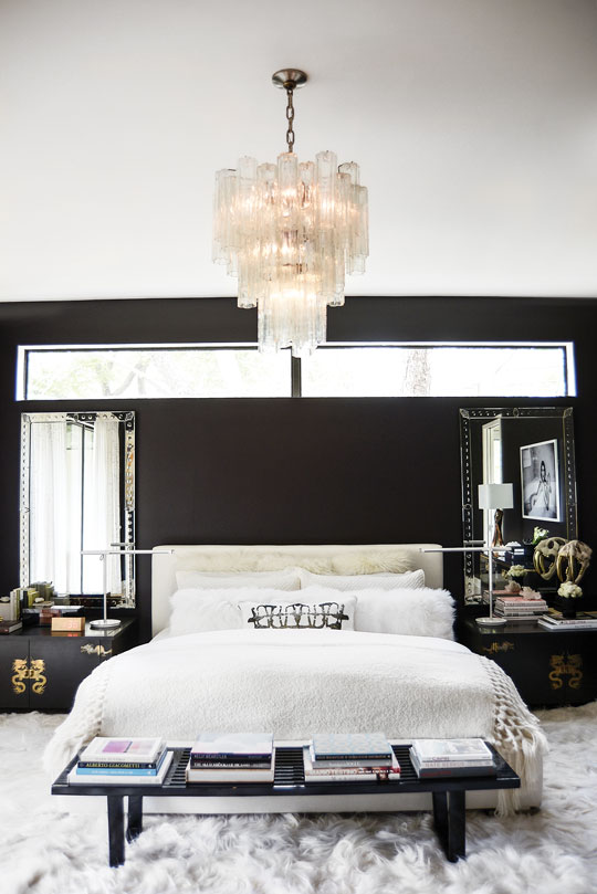 Farrow & Ball Tanner’s Brown No. 255 gives the master bedroom a subdued and moody feel. Custom white-linen headboard. Vintage Chinese chests with engraved brass dragons, which Clair purchased at an estate sale. Provocative black-and-white photo by L. A. fashion photographer Tatiana Gerusova from Gallerie Noir. Vintage Venini Italian chandelier. White Kidassia goat-fur rug.