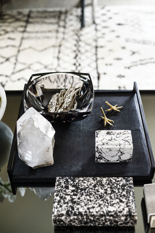 Mixed materials work magic on the custom smoked-mirror cube coffee table: R+Y Augousti shagreen tray and boxes,
Baccarat bowl, gold crow’s-feet sculptures from D.L. & Co. and a crystal found at an estate sale.