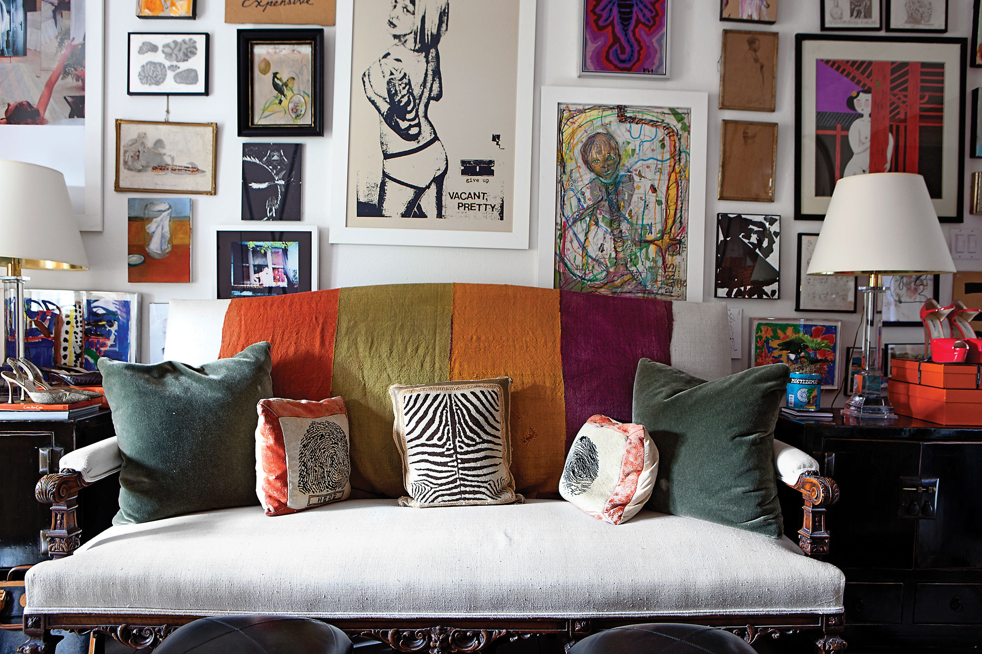 A wall in the office\sitting room off the master is devoted to a salonstyle hanging of art that Cathy has gathered throughout the years, centered around the focal piece Vacant, Pretty by the street artist Give Up — a gift from a friend. The French neoclassical settee is covered in a Clarence House raw silk and draped with a multicolored vintage Afghani tent hanging, two olive-colored mohair pillows and a collection of needlepoint pillows procured from the Herb Wells estate. Waterworks crystal column lamps.