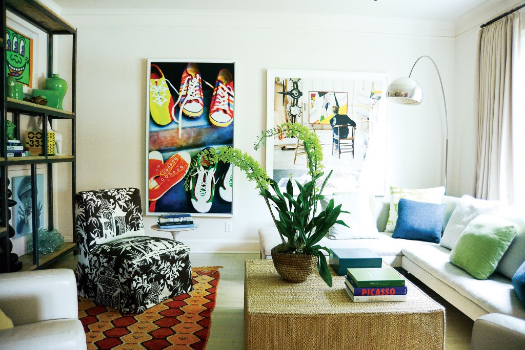 In the family room, from far left, artwork by Keith Haring, Tommy Crow (sneakers) and Laurie Lambrecht (Roy Lichtenstein in his studio). B&B Italia sofa and Arco floor lamp for Flos, both from Design Within Reach. Peyton ottoman used as coffee table, by Ralph Lauren. Custom chair covered in toile from Quadrille. Vintage Moroccan rug. Grammy orchid from Avant Garden.