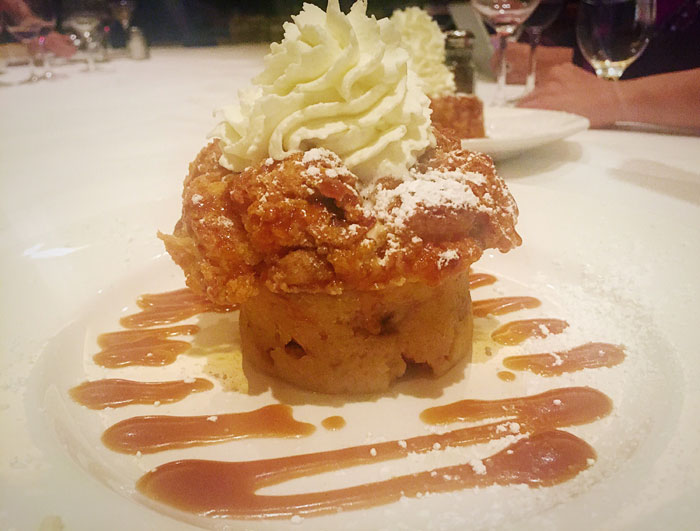 Del Frisco's warm vanilla bread pudding is served with caramel sauce and fresh whipped cream. 