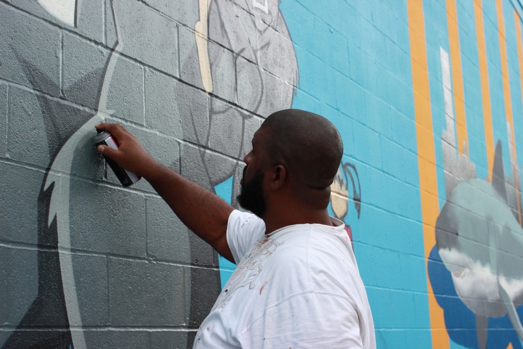 Deck WGF works on creatures in his mural. (300 N. York St.)