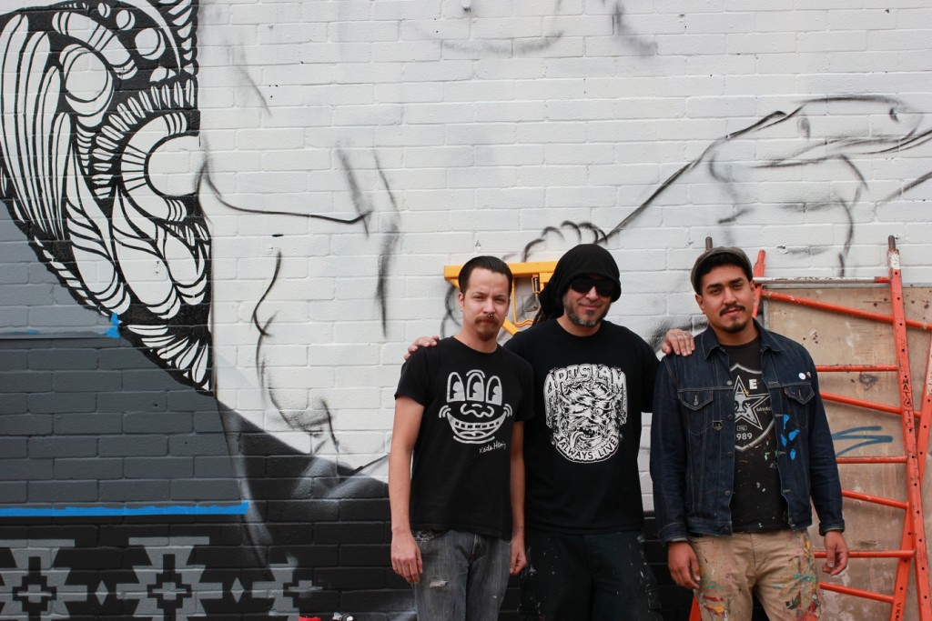 Los Otros – David Shek Vega, Nik Soupe and Christopher Montoya – stand near their mural. (4739 Canal)