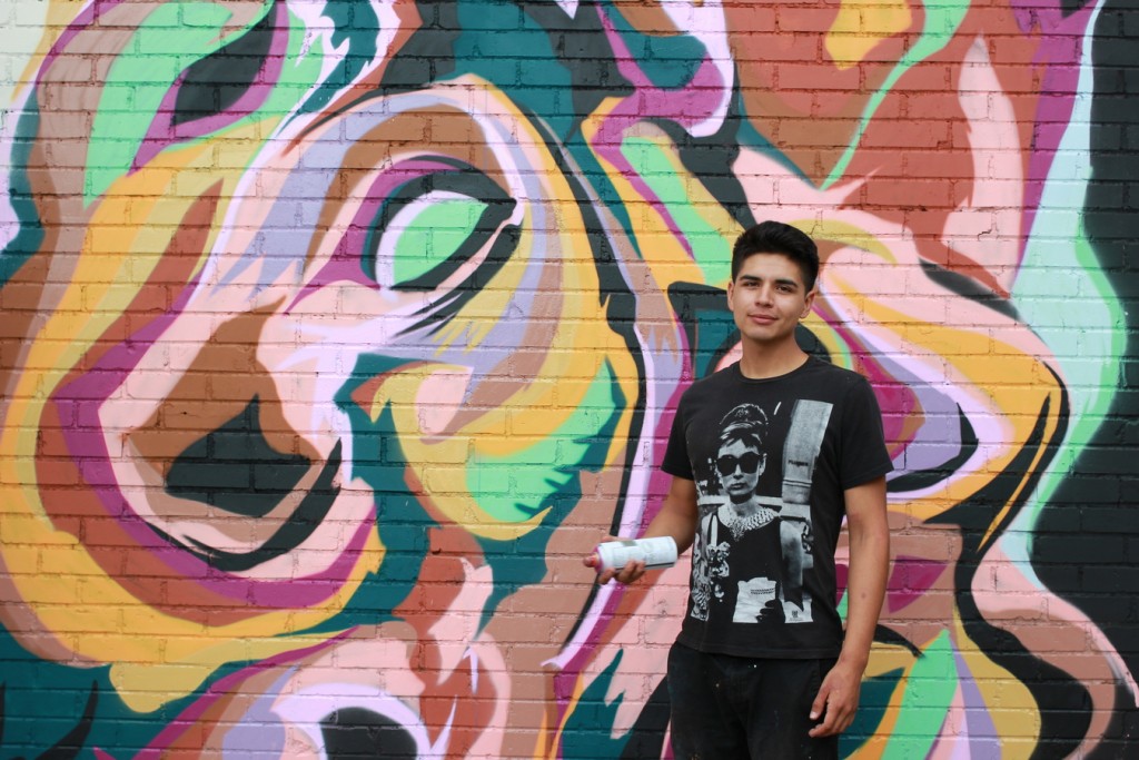 Leche, who resides in Houston, poses in front of his mural. (6697 Capitol) 