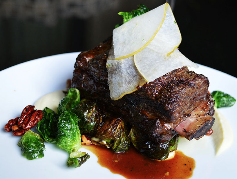 Monarch's 48-hour beef short rib is served with a parsnip purée, crispy Brussels sprouts, a bacon, pear and brussels salad, and candied pecans. (Photo courtesy Monarch)