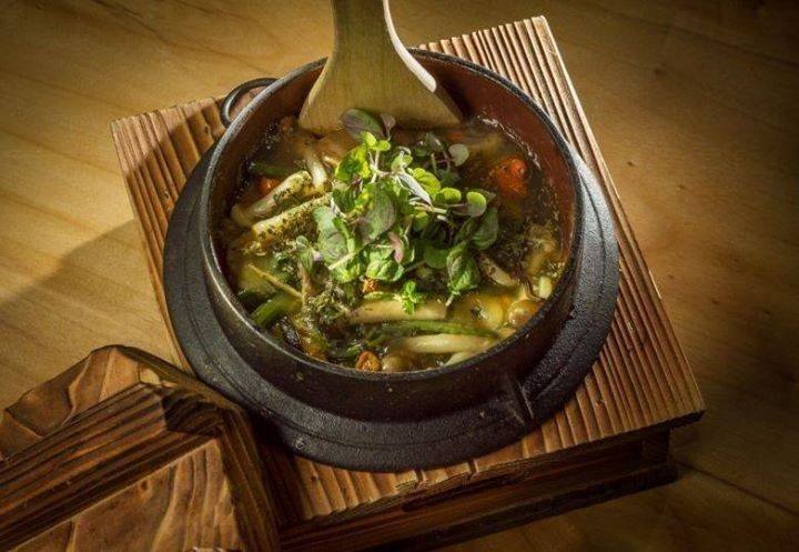 The restaurant's Japanese wild mushroom rice hot pot includes four types of wild mushrooms, tofu, and green beans, all layered over white rice. It is finished with mushroom stock and ginger juice. 