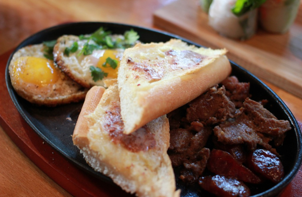 The steak and eggs at Les' Baget includes Vietnamese sausage, a buttered baguette and bone marrow paté. (Photo by Faith Nguyen)