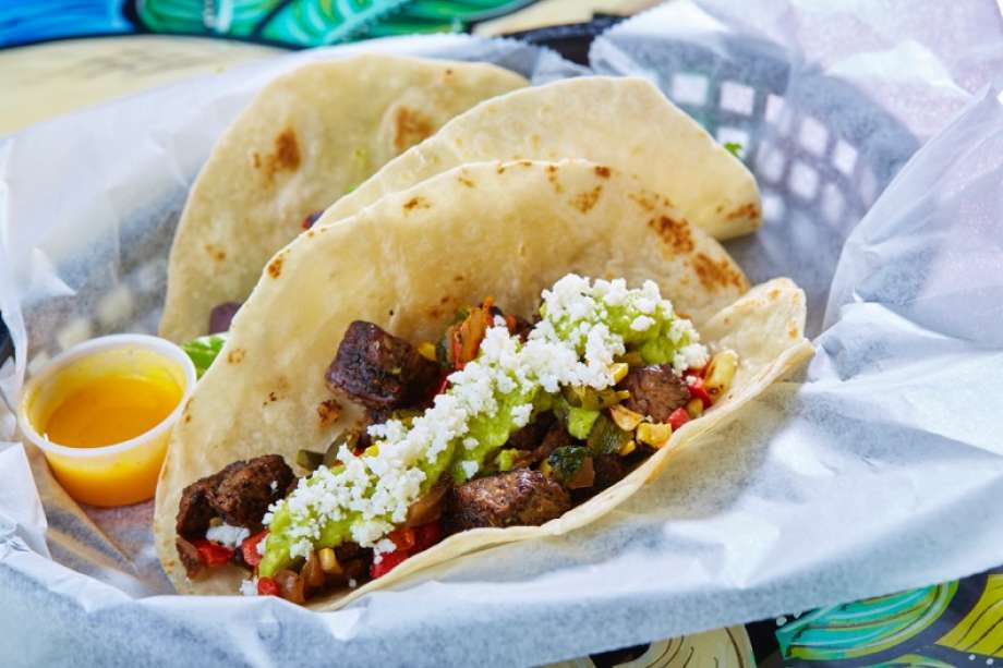 Tacodeli's Cowboy taco is comprised of a dry rubbed beef tenderloin, grilled corn, caramelized onions, roasted peppers, guacamole and queso fresco.