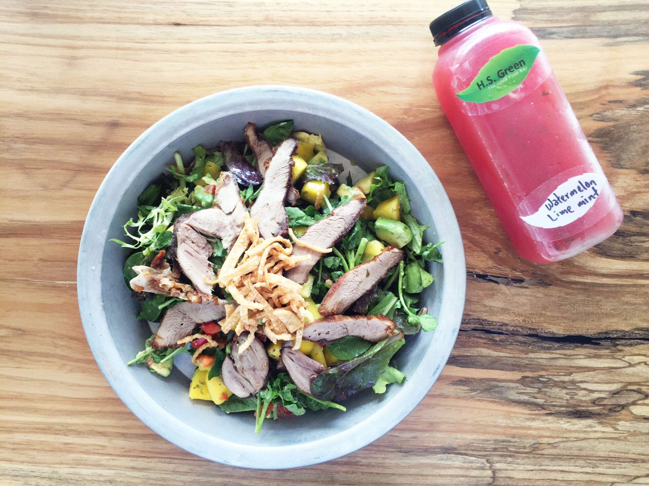 H.S. Green's Crispy Duck and Watercress salad pictured with a cold-pressed watermelon, lime and mint juice. (Photo by Jailyn Marcel)