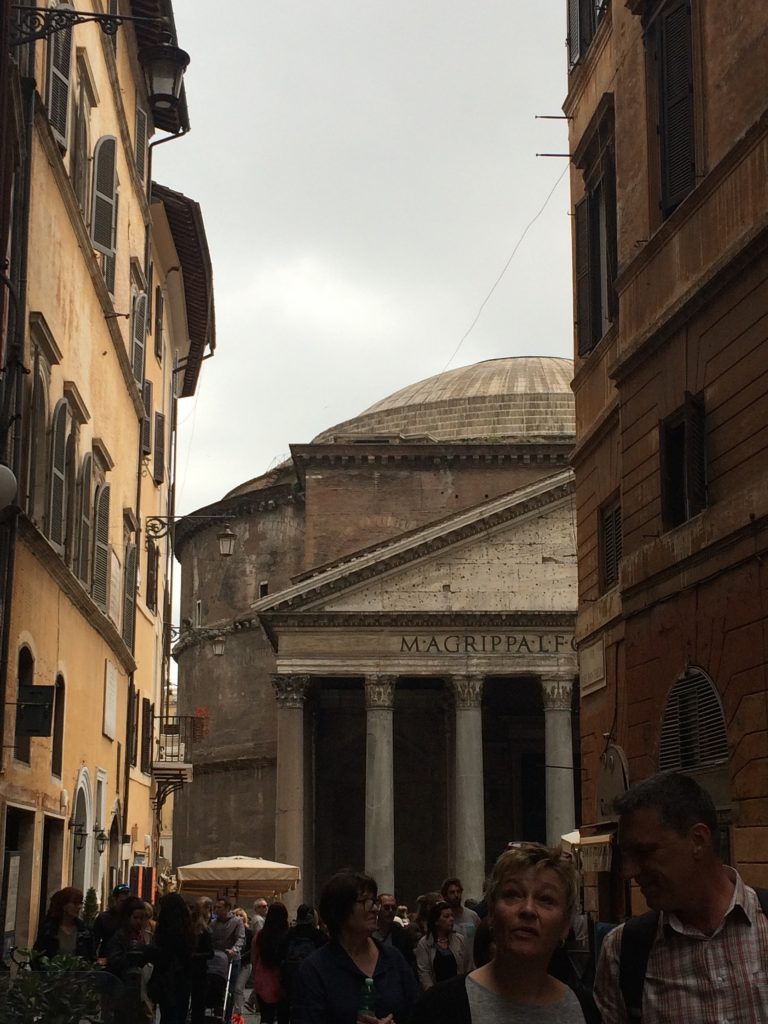 The Pantheon emerges at the end of the street.
