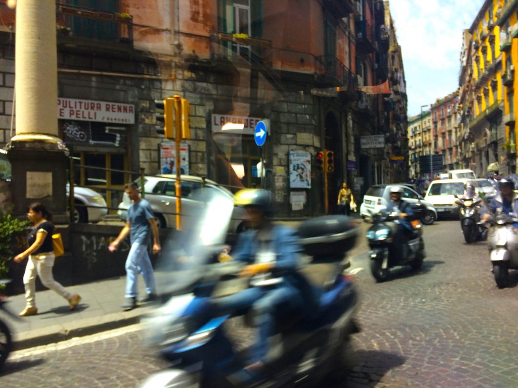 Speeding Vespas wisping through Naples.