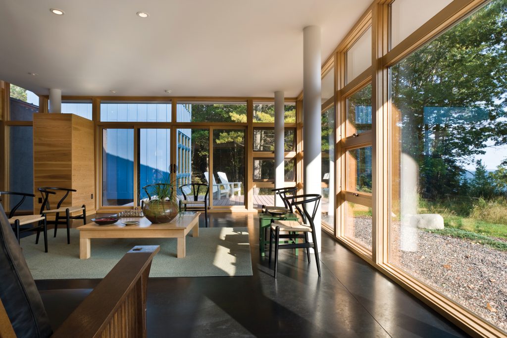 Andersen® E-Series awning and picture windows with Pine Andersen E-Series Picture Windows with pine interiors are right at home in this woodsy retreat.