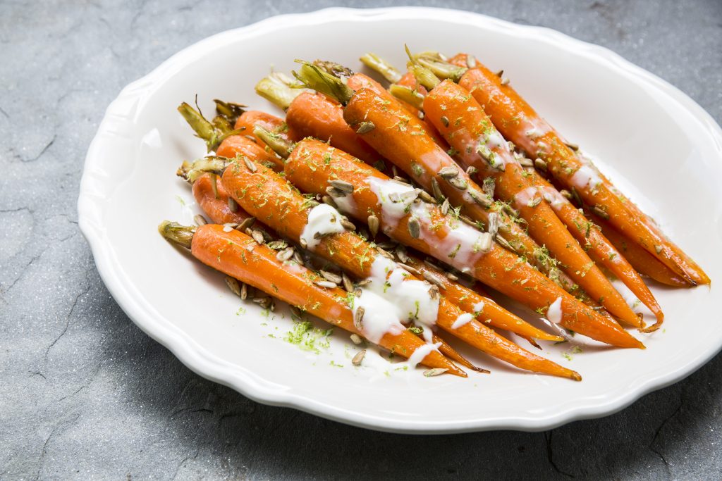 Relish's glazed carrots are topped with sunflower seeds and crème fraîche before being finished with lime zest. 