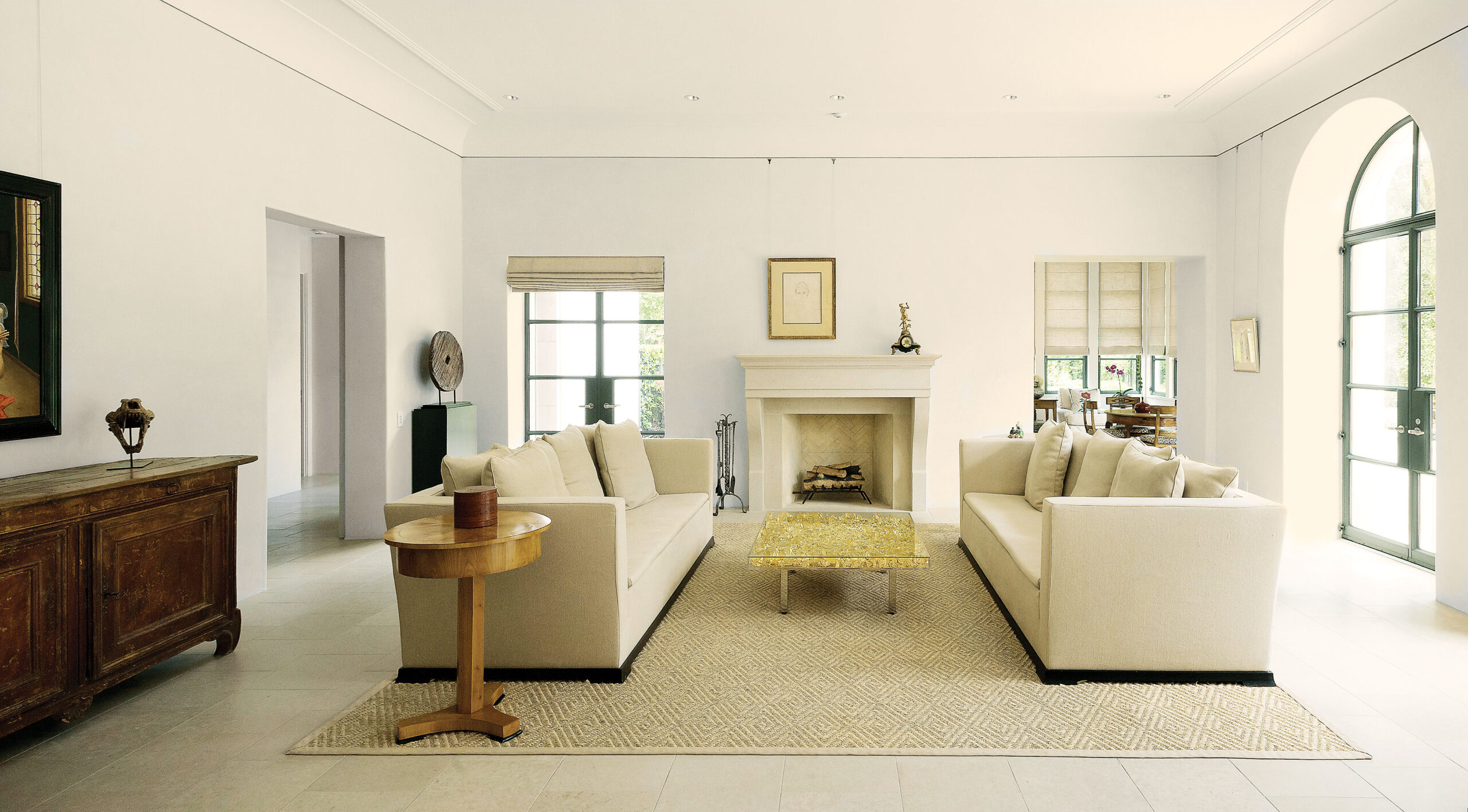 One end of the living room features two Armani Casa sofas from Kuhl-Linscomb, covered in beige linen. Between them, Yves Klein’s Table d’Or. In the foreground, one of a pair of Biedermeier-style tables from Eastern Europe; atop the table, an antique Burmese lacquer box.