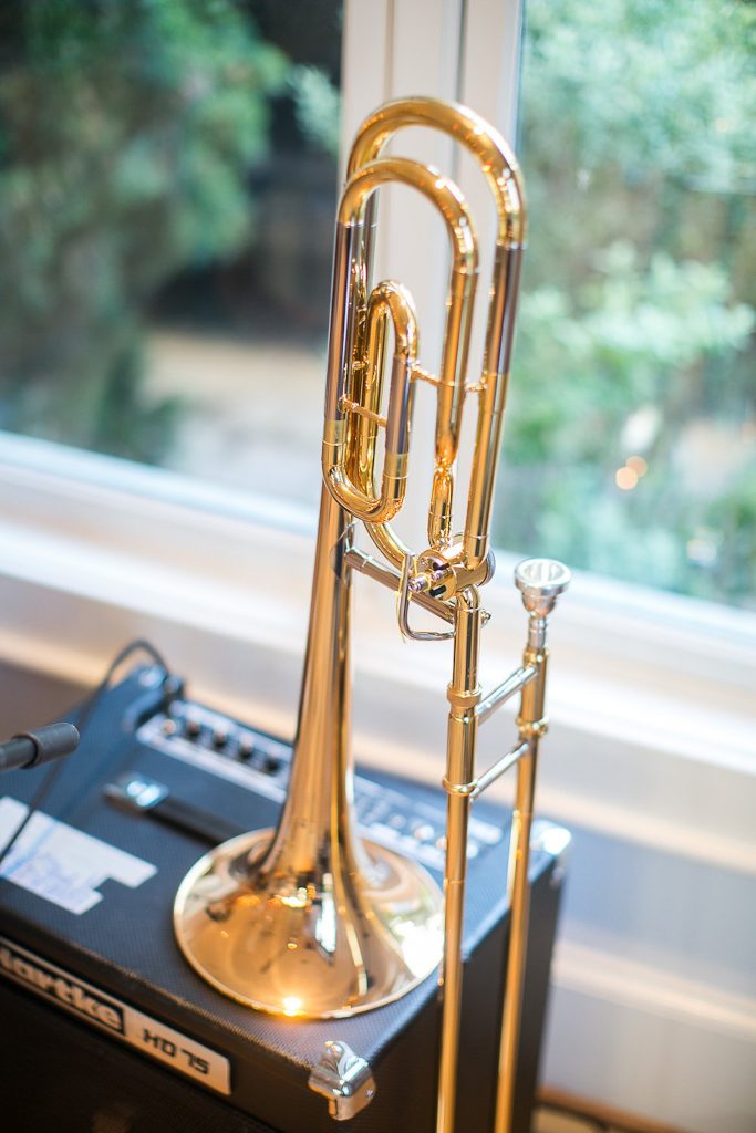 A trombone rests next to the band's equipment.