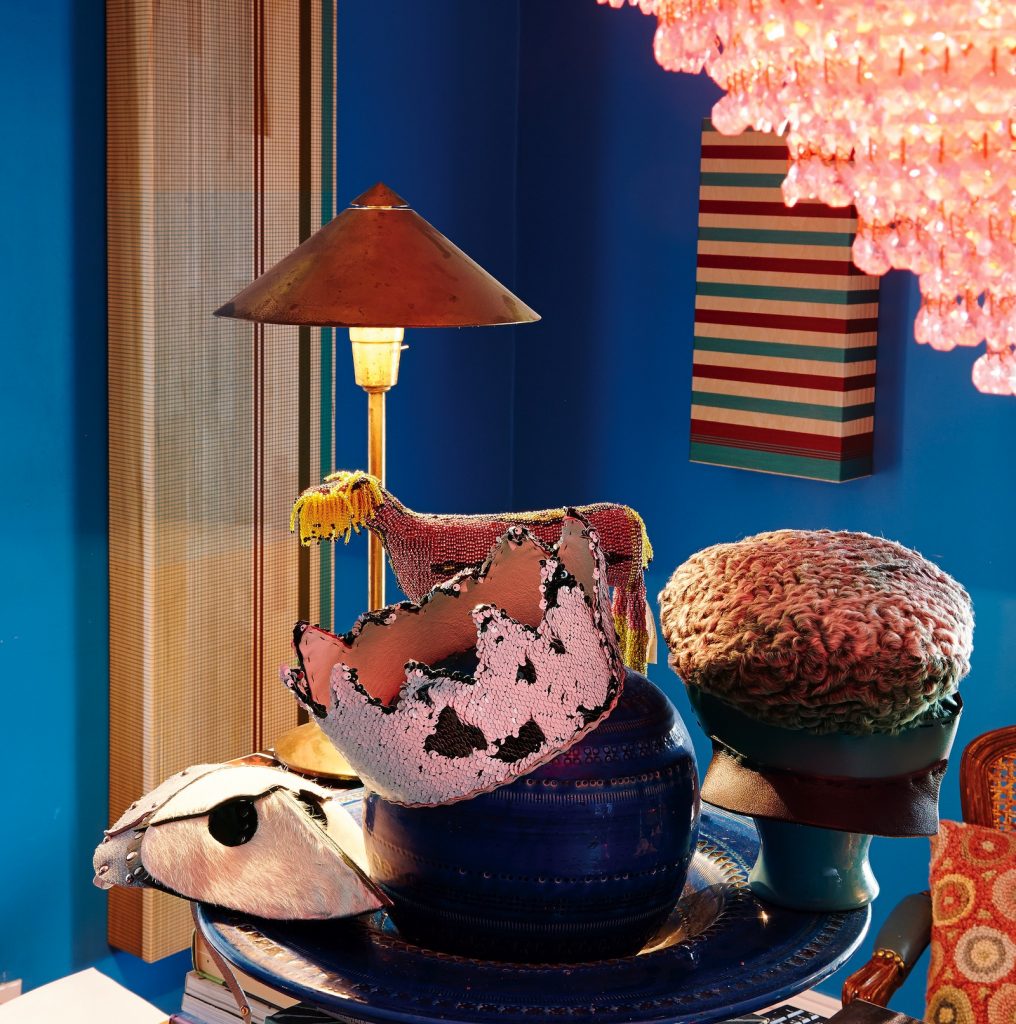 Dan & Joseph curly lamb police hat, $525; sequined crown, $350; and white pony-hair mask, $295. Untitled artworks by Gina Garza, from left: $3,200 and $1,200.